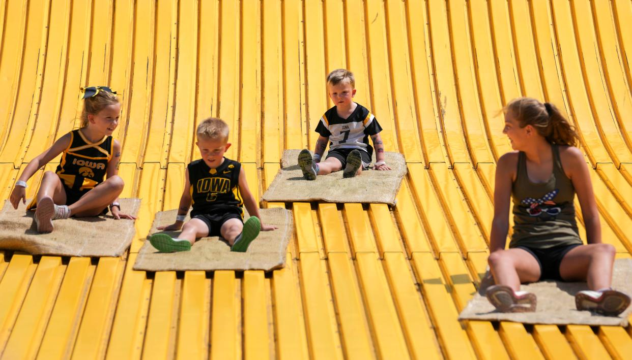 Tatum Roberts, 7, Dane Roberts, 5, Trey Roberts, 3, all of West Des Moines, Elyse Bartels, 11, ride the Giant Slide during the Iowa State Fair in 2022.