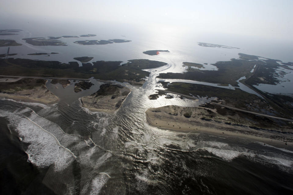 FILE - This Sunday, Aug. 28, 2011 file photo shows a flooded road on Hatteras Island, N.C., after Hurricane Irene swept through the area the previous day cutting the roadway in five locations. From Cape Hatteras, N.C., to just north of Boston, sea levels are rising much faster than they are around the globe, putting one of the world's most costly coasts in danger of flooding, according to a new study published Sunday, June 24, 2012, in the journal Nature Climate Change. By the year 2100, scientists and computer models estimate that sea levels globally could rise as much as 3.3 feet. The accelerated rate along the East Coast could add about another 8 to 11 inches, Asbury Sallenger Jr., an oceanographer for the USGS said. "Where that kind of thing becomes important is during a storm," Sallenger said. That's when it can damage buildings and erode coastlines. (AP Photo/Jim R. Bounds)