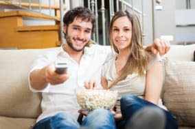 young couple preparing to watch ...