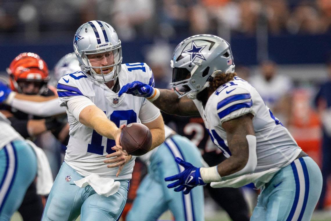 Dallas Cowboys quarterback Cooper Rush passes the ball to running back Ezekiel Elliott during the first quarter on Sunday, Sept. 18, 2022, at the AT&T Stadium in Arlington, Texas.