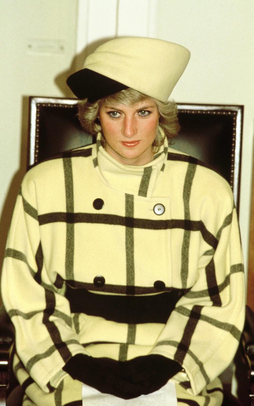 One of the Princess's boldest outfits: a yellow and black turban-style hat and overblown checked coat. Pictured here in 1987