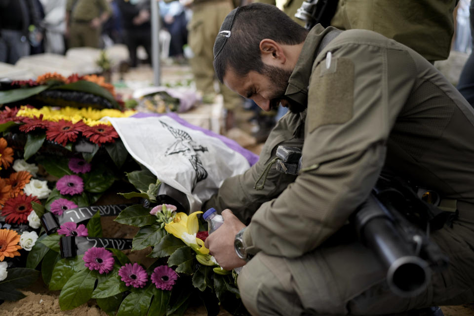 An Israeli soldier reacts next to the grave of reservist Master Sgt. Gil Daniels during his funeral in Ashdod, Israel, Wednesday, Dec. 6, 2023. Daniels was killed in Gaza during an Israeli military ground offensive against the enclave's militant Hamas rulers. (AP Photo/Leo Correa)