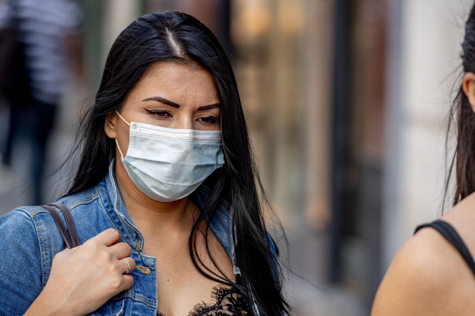 ANTWERP, BELGIUM - 2020/07/20: A woman wearing a face mask as a preventive measure walks on the street during the coronavirus crisis. The wearing of a face mask will become compulsory from Saturday in shops and some other indoor spaces where people gather. (Photo by Robin Utrecht/SOPA Images/LightRocket via Getty Images)