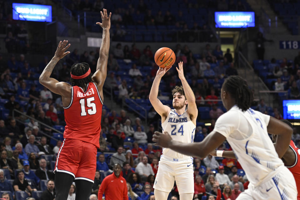 Saint Louis' Gibson Jimerson, center, goes up for a shot against Dayton's DaRon Holmes II, left, during the second half of an NCAA college basketball game Tuesday, March 5, 2024, in St. Louis. (AP Photo/Joe Puetz)