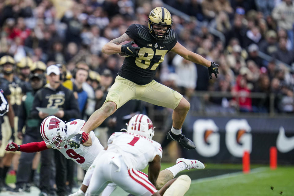 Purdue tight end Payne Durham (87) attempts to leap over Wisconsin safety Scott Nelson (9) and cornerback Faion Hicks (1) during the second half of an NCAA college football game in West Lafayette, Ind., Saturday, Oct. 23, 2021. Wisconsin defeated Purdue 30-13. (AP Photo/Michael Conroy)