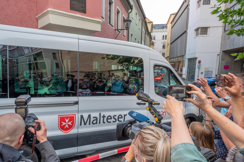 21 June 2020, Bavaria, Regensburg: The emeritus Pope Benedict XVI (l) waves from a bus to the onlookers in front of his brother's house. The former Pope Benedict spent four days in his old home country. Twice a day he visited his 96 years old brother Georg Ratzinger. The stay is to end on Monday. Photo: Armin Weigel/dpa (Photo by Armin Weigel/picture alliance via Getty Images)