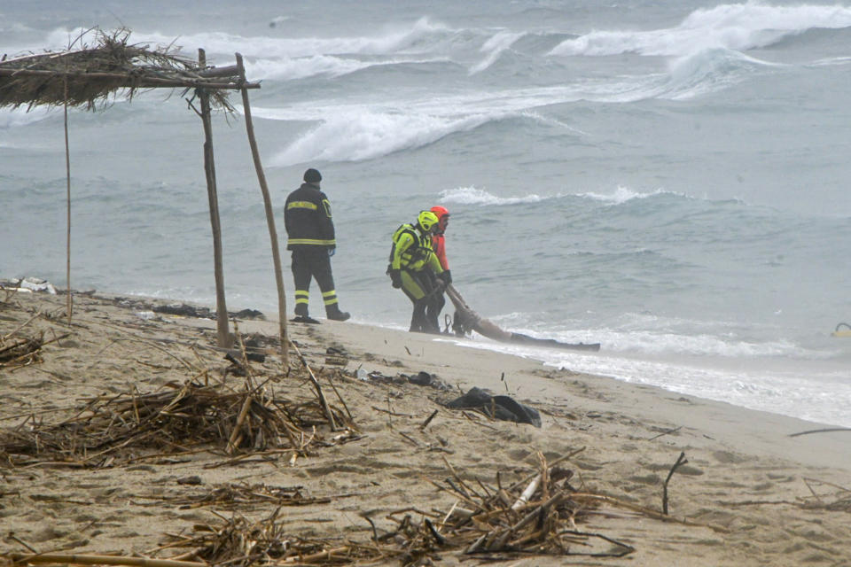 Rescuers recover a body at a beach near Cutro, southern Italy, after a migrant boat broke apart in rough seas on Sunday, Feb. 26, 2023. Rescue officials say an undetermined number of migrants have died and dozens have been rescued after their boat broke apart off southern Italy. (AP Photo/Giuseppe Pipita)