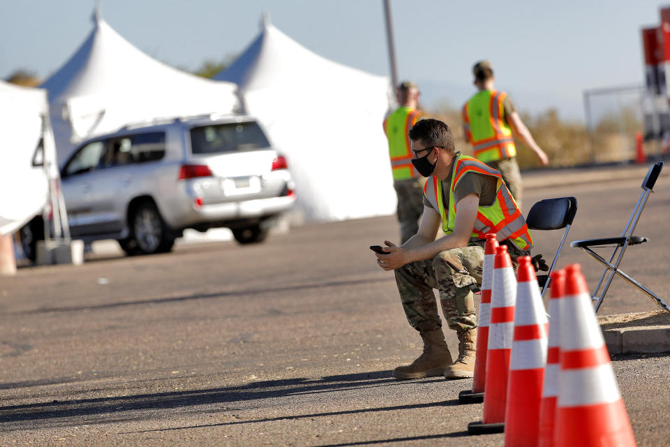 A National Guard solider waits to direct traffic as only one vehicle with people pulls up to be tested for the COVID-19 Coronavirus Tuesday, July 28, 2020 at South Mountain Park in Phoenix. It was the last day of a 12-day blitz aimed at bringing tens of thousands of COVID-19 tests to underserved Latino communities in Phoenix but only 14,000 of some 55,000 tests were administered at the park and the western neighborhood of Maryvale, leaving more than 40,000 COVID-19 test kits unused. (AP Photo/Matt York)