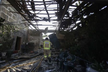 A fireman walks through a destroyed house after an explosion in a fireworks storage facility in Paramos, Spain, May 23, 2018. REUTERS/Miguel Vidal
