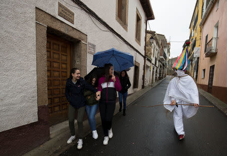 A reveller, dressed as a "Zarramache", chases a group of young girls during celebrations to mark Saint Blaise festivity in Casavieja, Spain February 3, 2017. REUTERS/Sergio Perez