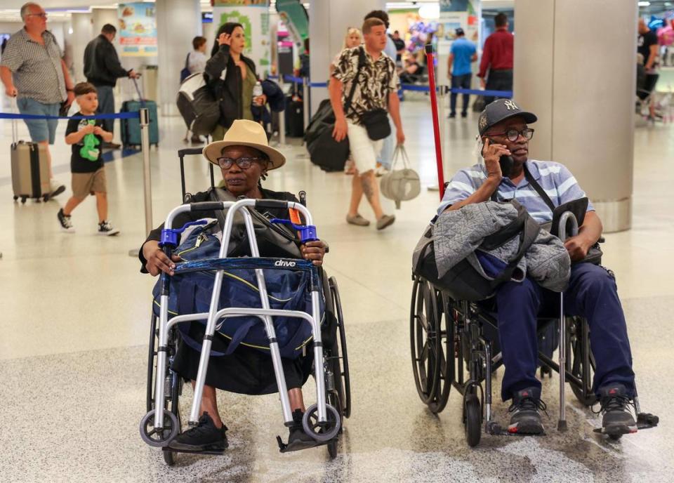 Marie Lucie St. Fleur, left, sits in the Arrivals area after arriving on the first evacuation flight out of Cap-Haitien, Haiti, that landed at Miami International Airport after the suspension of flights nearly two ago after some Haitian-Americans evacuated and returned to the United States on Sunday, March 17, 2024.