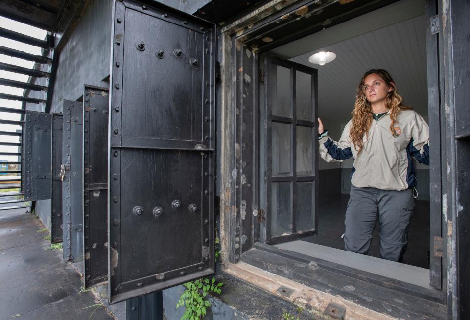 National Park Service visual information specialist intern Nava Kiss looks out a window July 13 in the guardroom at the recently reopened Battery Cooper at Fort Pickens.