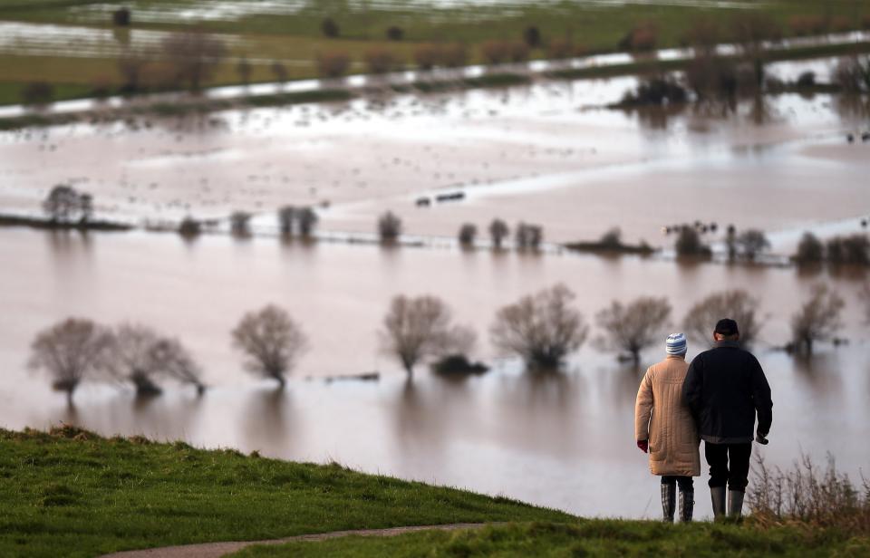 GLASTONBURY, UNITED KINGDOM - NOVEMBER 25: People walk from Glastonbury Tor as flood water in the fields below is seen, on November 25, 2012 in Somerset, England. Another band of heavy rain and wind continued to bring disruption to many parts of the country today particularly in the south west which was already suffering from flooding earlier in the week. (Photo by Matt Cardy/Getty Images)