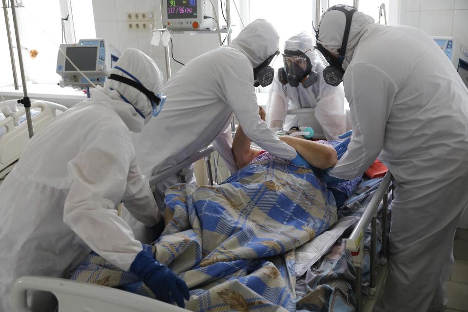 Medical staff members wearing special suits to protect against coronavirus treat a patient with coronavirus at an ICU of the Clinical hospital in Volgograd, Russia, Monday, Jan. 31, 2022. Russia's state coronavirus task force reported a total of 11.8 million confirmed cases in the pandemic and 331,349 deaths — by far the highest death toll in Europe. However, reports by Russia's state statistics service Rosstat, which uses wider criteria for counting virus-linked deaths, revealed much higher numbers. (AP Photo/Alexandr Kulikov)