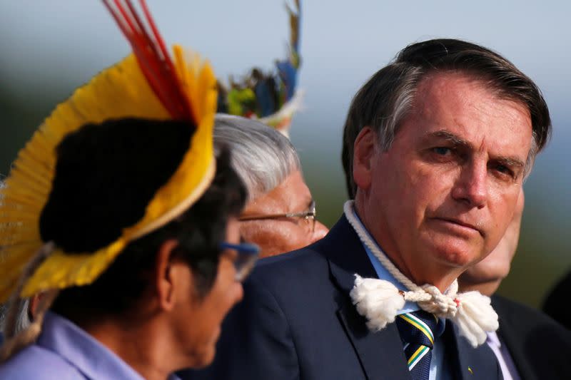 Brazil's President Jair Bolsonaro and Brazilian Indians from different ethnic groups attend a national flag hoisting ceremony in front the Alvorada Palace in Brasilia