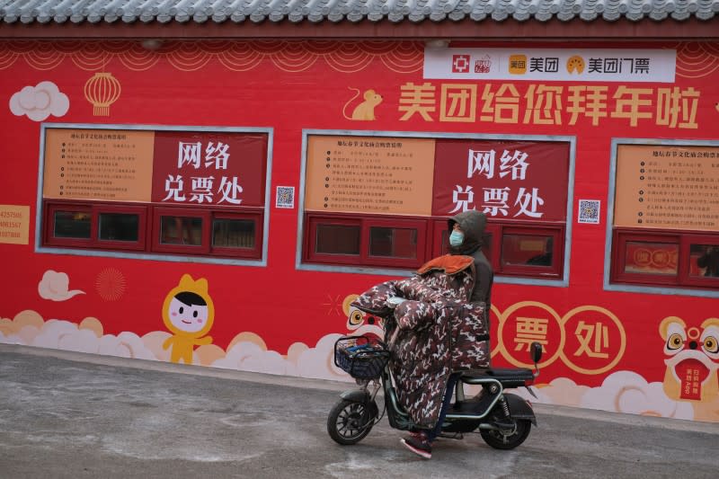 A man rides on his scooter in front of a closed ticket office for internet bookings after the temple fair for the Chinese Lunar New Year in Ditan Park was canceled in Beijing