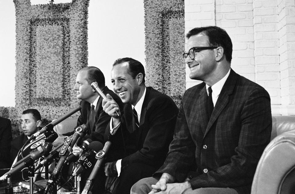 FILE - Pete Rozelle grins as he answers questions about a merger agreement between the National and American Football leagues in New York, June 9, 1966. At left is Tex Schramm, NFL President and head of the Dallas Cowboys. At right is Lamar Hunt, president of the Kansas City Chiefs. Rozelle never liked the name that was half-jokingly suggested by Kansas City Chiefs owner Lamar Hunt for the first annual game between the champions of the NFL and the AFL. Hunt agreed, telling the NFL commissioner they could surely think of something better to call it than the Super Bowl. (AP Photo/John Duricka, File)