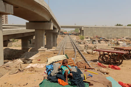 A child from a homeless family sits on a bed, on the track of the disused Karachi Circular Railway line in Karachi, Pakistan, May 23, 2017. REUTERS/Caren Firouz