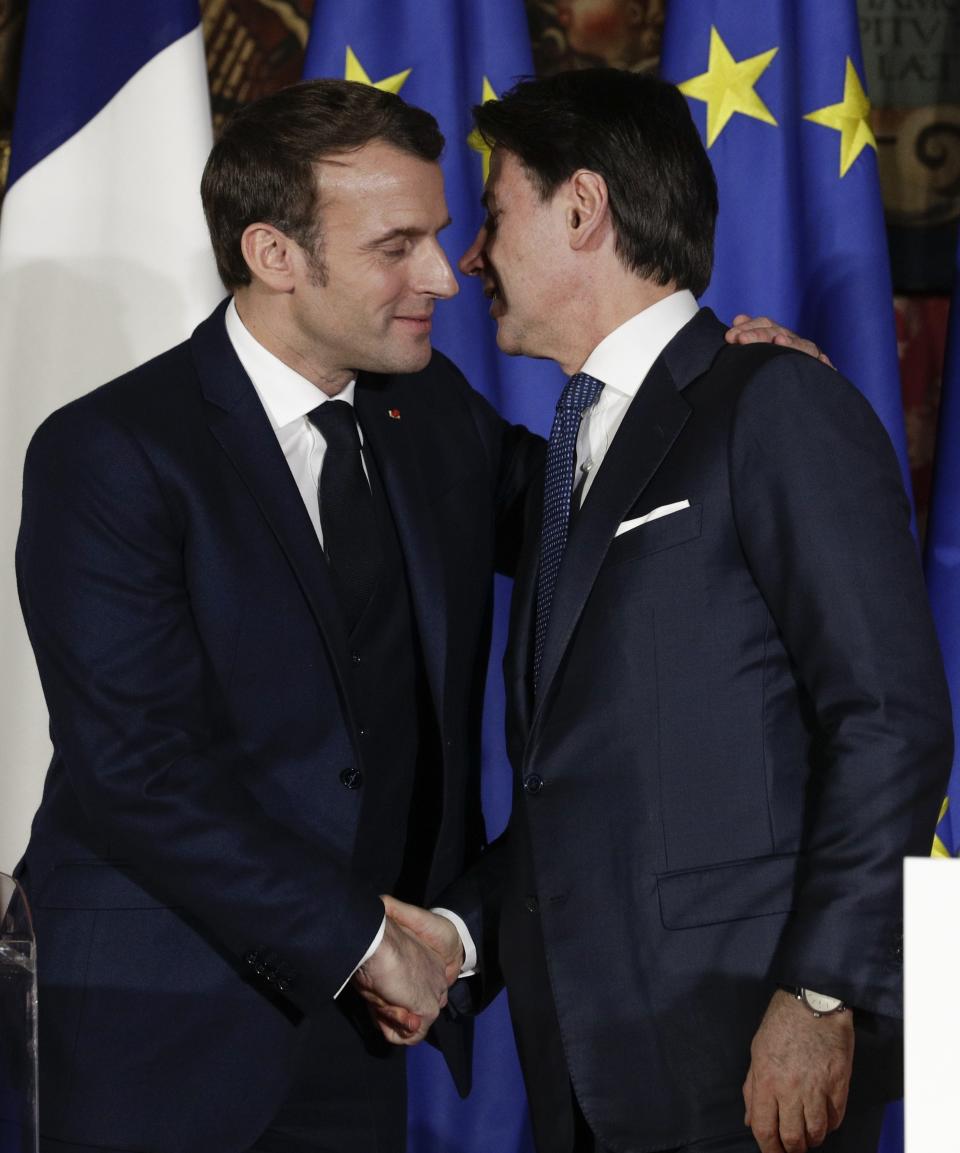 French President Emmanuel Macron, left, puts his arm around the shoulder of Italian Premier Giuseppe Conte and gives him a kiss on both cheeks during a joint press conference on the occasion of the first French-Italian summit in more than two years, in Naples, southern Italy, Thursday, Feb. 27, 2020. (AP Photo/Andrew Medichini)