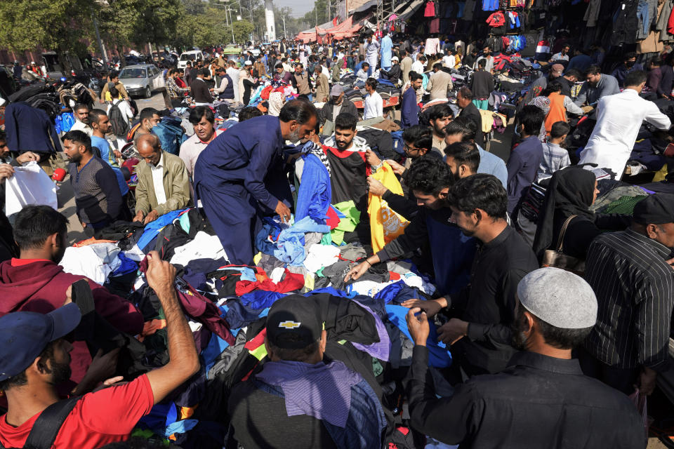 Pakistani people shops in Lahore, Pakistan, Monday, Nov. 13, 2022. The world's population is projected to hit an estimated 8 billion people on Tuesday, Nov. 15, according to a United Nations projection. (AP Photo/K.M. Chaudary)