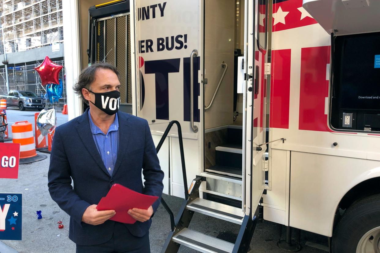 Fulton County Registration and Elections Director Richard Barron stands outside the county's new mobile voting vehicle in October 2020. After the election, he says, he and his staff plunged into a world of threats and harassment.