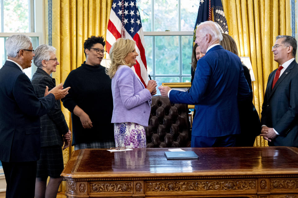 President Joe Biden, accompanied by National Academy of Medicine President Dr. Victor Dzau, left, White House Initiative on Women's Health Research chair Dr. Carolyn Mazure, second from left, Office of Management and Budget director Shalanda Young, third from left, and Health and Human Services Secretary Xavier Becerra, gives first lady Jill Biden the pen he used to sign a presidential memorandum that will establish the first-ever White House Initiative on Women's Health Research in the Oval Office of the White House, Monday, Nov. 13, 2023, in Washington. (AP Photo/Andrew Harnik)
