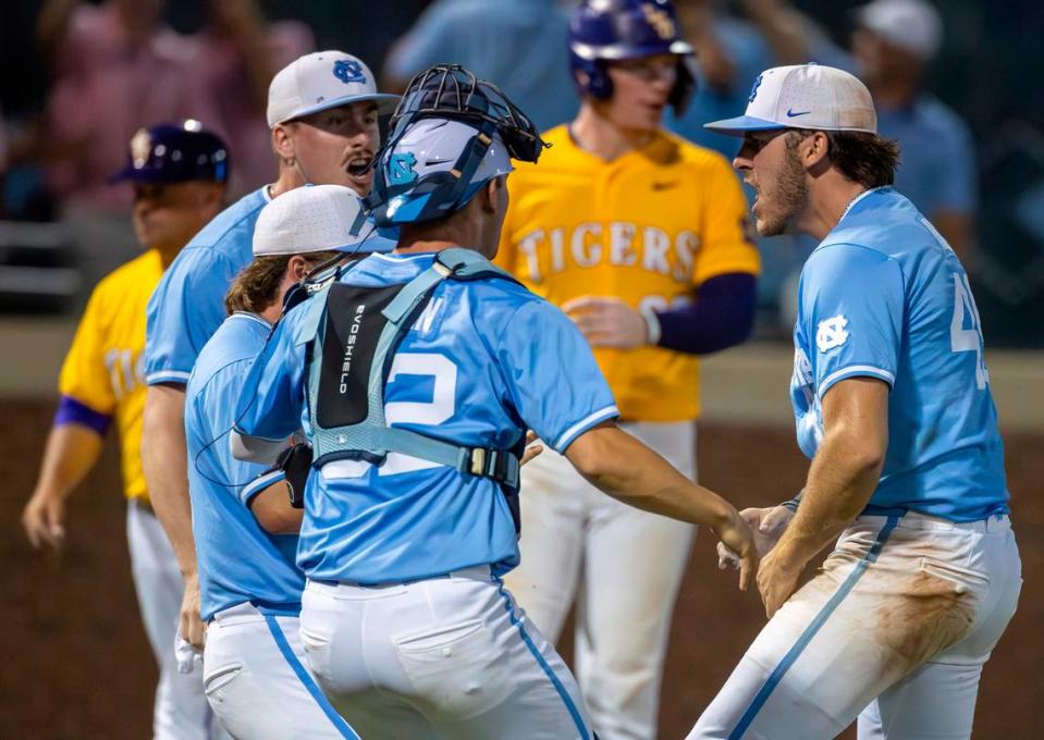 North Carolina teammates Hunter Stokely (45), Patrick Alvarez (8) and Luke Stevenson (44) celebrate with closing pitcher Dalton Pence (49) after defeating LSU 4-3 in the tenth inning clinching their NCAA Regional on Monday, June 3, 2024 at Boshamer Stadium in Chapel Hill, N.C.