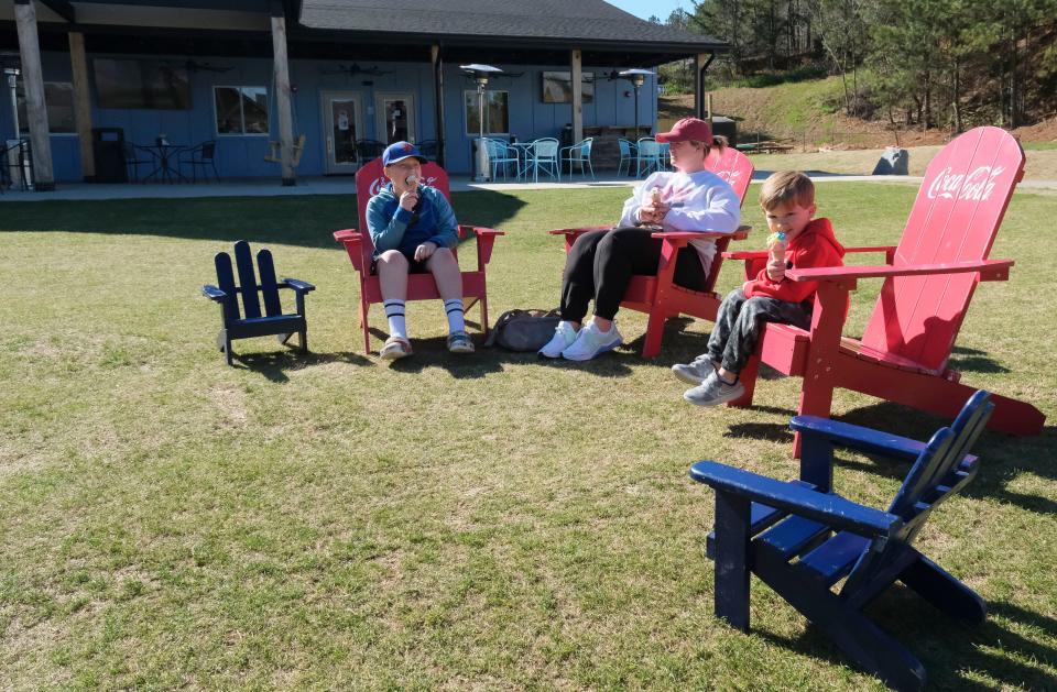 Mar 14, 2023; Tuscaloosa, AL, USA;  Landry, Heather and Ford Rhodes enjoy ice cream from LizaÕs Sweet Shoppe at The Venue, a collection of restaurants, a bar, and entertainment venue on Watermelon Rd. in Tuscaloosa.