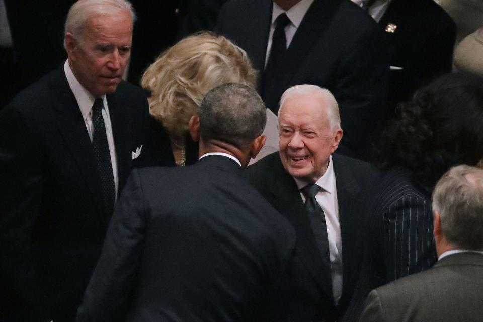 <p>Former presidents Barack Obama and Jimmy Carter greet one another.</p>