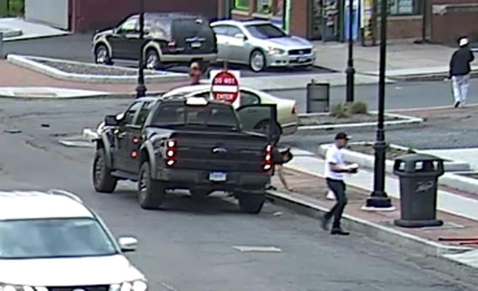 In one of the surveillance clips, police noticed a woman with Fotis Dulos — she can be seen reaching towards the sidewalk [right side of truck]. She was later identified as his girlfriend, Michelle Troconis. / Credit: Jon Schoenhorn