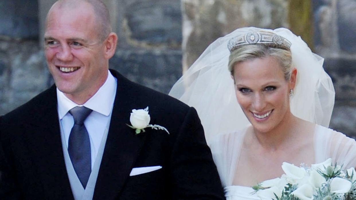 Zara Phillips and Mike Tindall smiling and linking arms on their wedding day