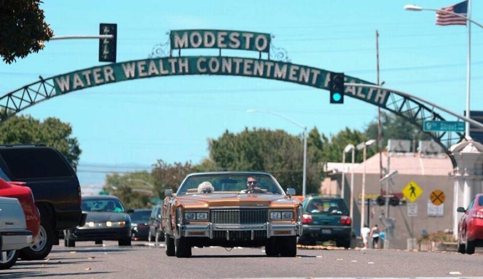 El artista de hip-hop Macklemore y su abuela, Helen Schott, aparecen conduciendo cerca del arco de Modesto en I Street en un cuadro de su video musical 'Glorious'.