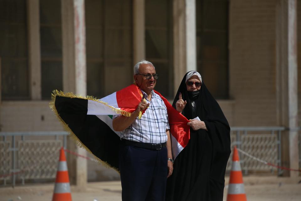 A man and his wife show their ink-marked fingers after casting their votes inside a polling station in the country's parliamentary elections in Najaf, Iraq, Sunday, Oct. 10, 2021. Iraq closed its airspace and land border crossings on Sunday as voters headed to the polls to elect a parliament that many hope will deliver much needed reforms after decades of conflict and mismanagement. (AP Photo/Anmar Khalil)