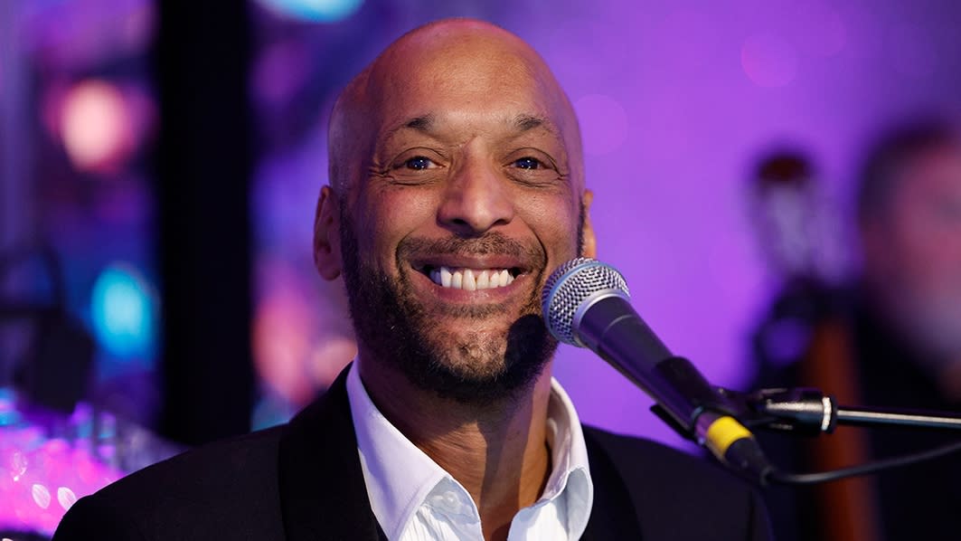  Tommy Blaize - Strictly Come Dancing singer smiling with a microphone . 