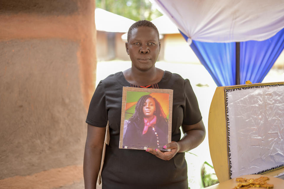 Winnie Akinyi, elder sister to Rose Bella Awuor, 31 years, holds her late sister's portrait ahead of her burial in Awendo, Migori County, Kenya Thursday, April. 11, 2024. Awuor fell ill in December and lost her five-month pregnancy before succumbing to malaria. It was the latest of five deaths in this family attributed to malaria. The disease is endemic to Kenya and is preventable and curable, but poverty makes it deadly for those who can't afford treatment. (AP Photo/Brian Ongoro)