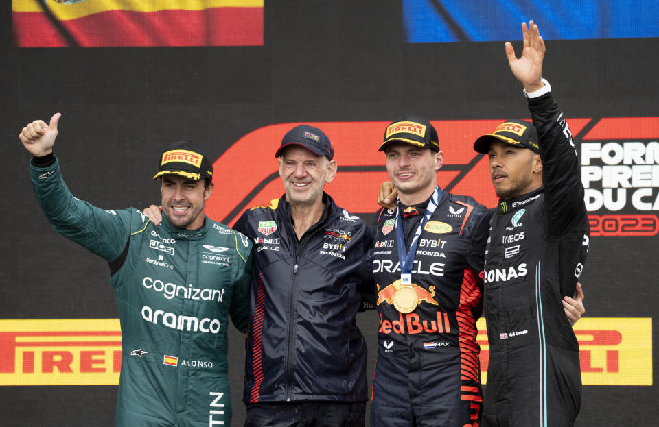 Winner Red Bull Racing's Max Verstappen, of the Netherlands, and his technical director, Adrain Newey, stand next to second place finisher Aston Martin driver Fernando Alonso, left, of Spain, and third place Mercedes driver Lewis Hamilton of the United Kingdom, during victory ceremonies following the Formula One Canadian Grand Prix auto race Sunday, July 18, 2023, in Montreal. (Paul Chiasson/The Canadian Press via AP)