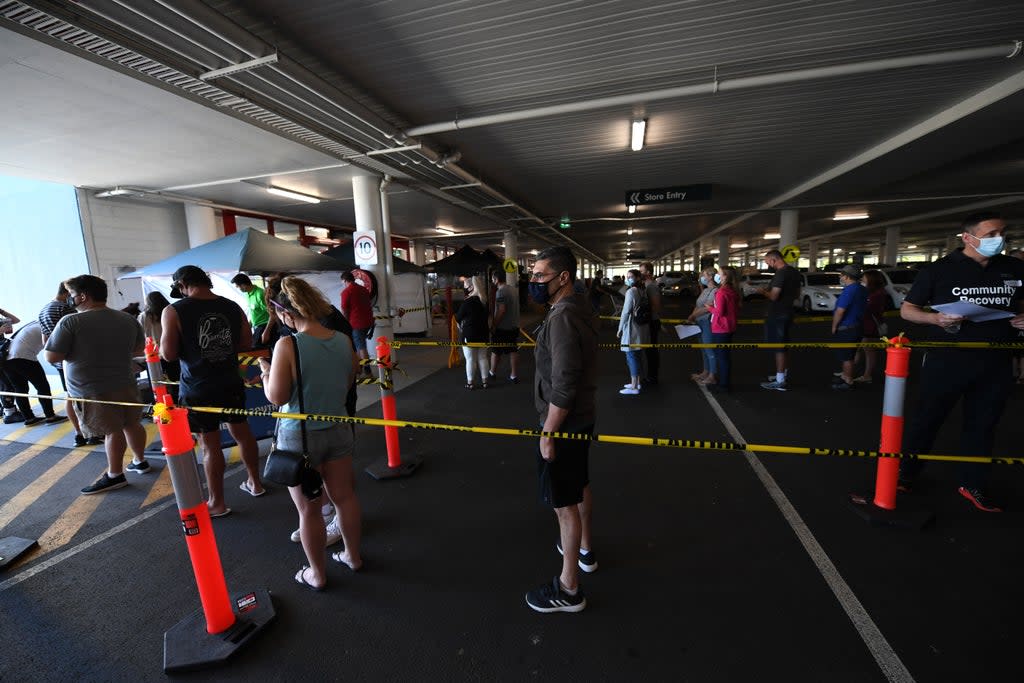 People line up to receive a Covid-19 vaccine at a Bunnings hardware store on 16 October in Brisbane, Australia (Getty Images)