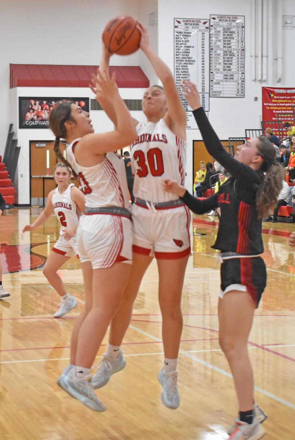 Coldwater's Coley Burkhardt (30) and Elli Foley battle for a rebound versus Marshall on Friday