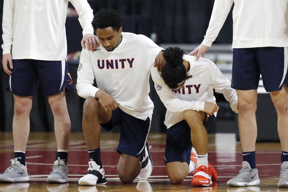 Virginia players kneel during the national anthem before an NCAA college basketball game against Boston College, Saturday, Jan. 9, 2021, in Boston. (AP Photo/Michael Dwyer)