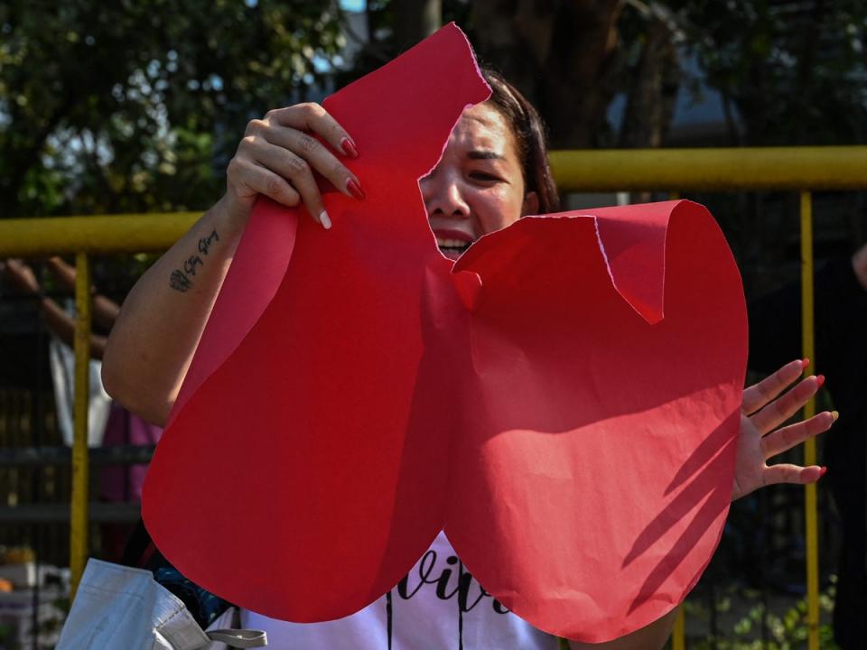 A pro-divorce protester tears a heart-shaped piece of paper during a demonstration (AFP via Getty Images)