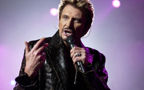 File photo taken on December 15, 2003 shows French singer Johnny Hallyday performing on stage in Paris. - Credit:  BERTRAND GUAY/AFP