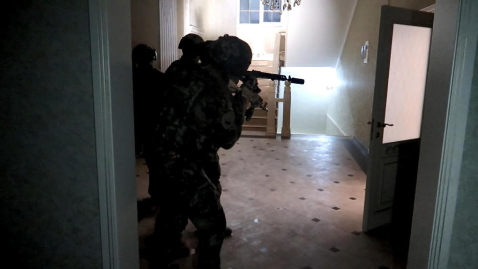 Police officers clear a building after more than 15 police officers were killed in Dagestan, Russia.