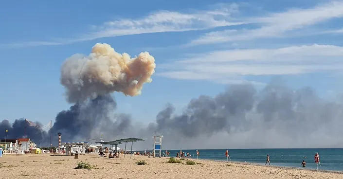 Rising smoke can be seen from the beach at Saky after explosions were heard from the direction of a Russian military airbase near Novofedorivka, Crimea, Tuesday Aug. 9, 2022. The explosion of munitions caused a fire at a military air base in Russian-annexed Crimea Tuesday but no casualties or damage to stationed warplanes, Russia's Defense Ministry said. (UGC via AP)