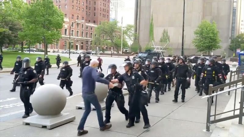 An elderly man appears to be shoved by riot police in Buffalo during a protest against the death in Minneapolis police custody of George Floyd