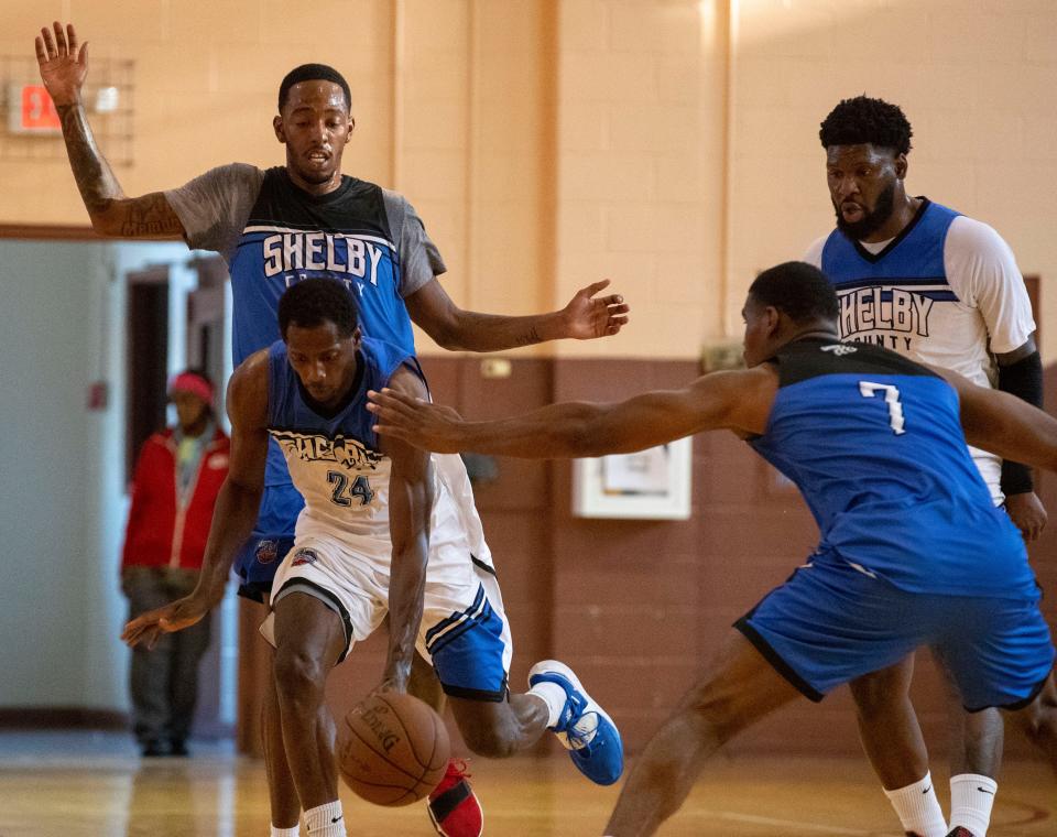 Shelby County Pro-Am white team’s Tayloe Taylor (24) keeps hold of the ball as he is guarded by blue team’s T.J. Moss (4) and Mike Campbell (7)  during a game Wednesday, July 20, 2022, at Orange Mound Community Center in Memphis. The Shelby County Pro-Am is a basketball league that features both current and former college and professional basketball players.