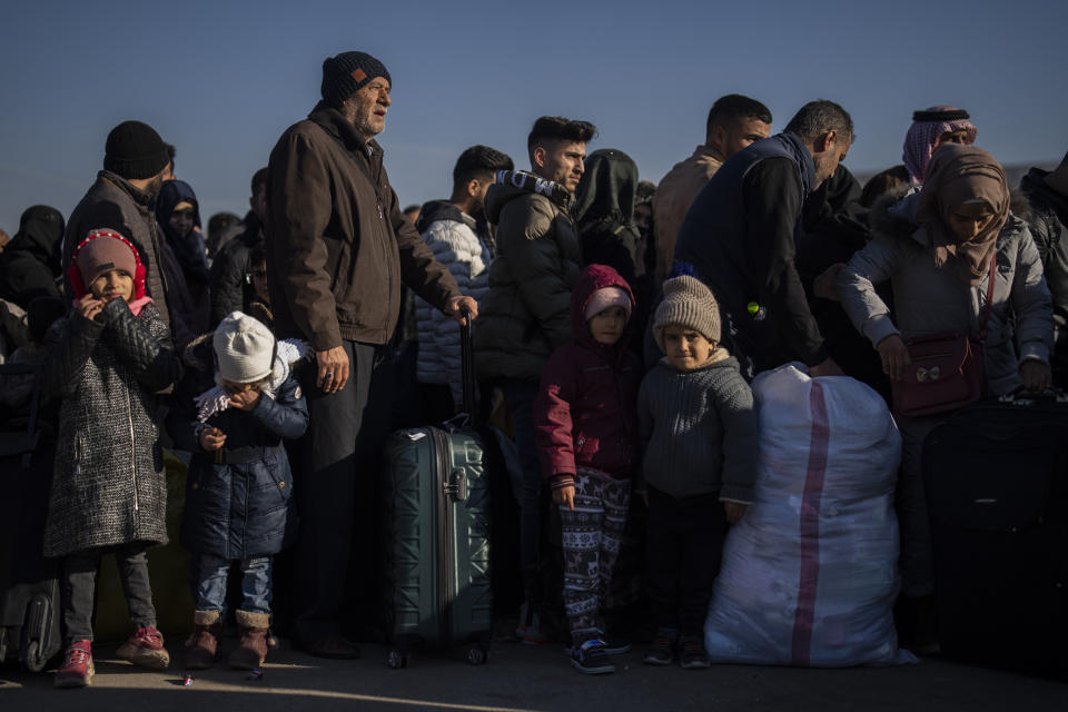 Syrians stand in a queue as they wait to return to their country from the Turkish crossing point of Cilvegozu, in Reyhanli, southeastern Turkey, Saturday, Feb. 18, 2023. A 7.8 magnitude earthquake with its epicenter in Turkey's southeastern Kharamanmaras province struck in the early hours of Feb. 6, followed by multiple aftershocks, including a major one magnitude 7.5 nine hours after the first tremor. (AP Photo/Bernat Armangue)