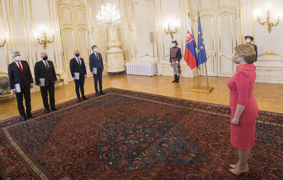 Slovakia's President Zuzana Caputova, right, stands opposite from left, outgoing Foreign Affairs Minister Ivan Korcok, Defence Minister Jaroslav Nad commissioned to head Slovak diplomacy on a temporary basis, outgoing Education Minister Branislav Groehling and Finance Minister Eduard Heger commissioned to head Education Ministry on a temporary basis, as the two ministers resign, at the Presidential Palace in Bratislava, Slovakia, Thursday, March 25, 2021. A party in Slovakia’s ruling coalition has completed its withdrawal from the government amid a political crisis triggered by a secret deal to buy Russia’s coronavirus vaccine. Two ministers of the Freedom and Solidarity party, the foreign minister and education minister, handed in their resignations to President Zuzana Caputova on Thursday. Their party leader resigned from his post of deputy prime minister on Monday. The Freedom and Solidarity and another coalition party, For People, demanded the resignation of Prime Minister Igor Matovic due to the deal he orchestrated. (Martin Baumann/TASR via AP)