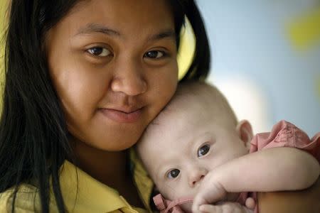 Gammy, a baby born with Down's Syndrome, is held by his surrogate mother Pattaramon Janbua at a hospital in Chonburi province August 3, 2014. REUTERS/Damir Sagolj