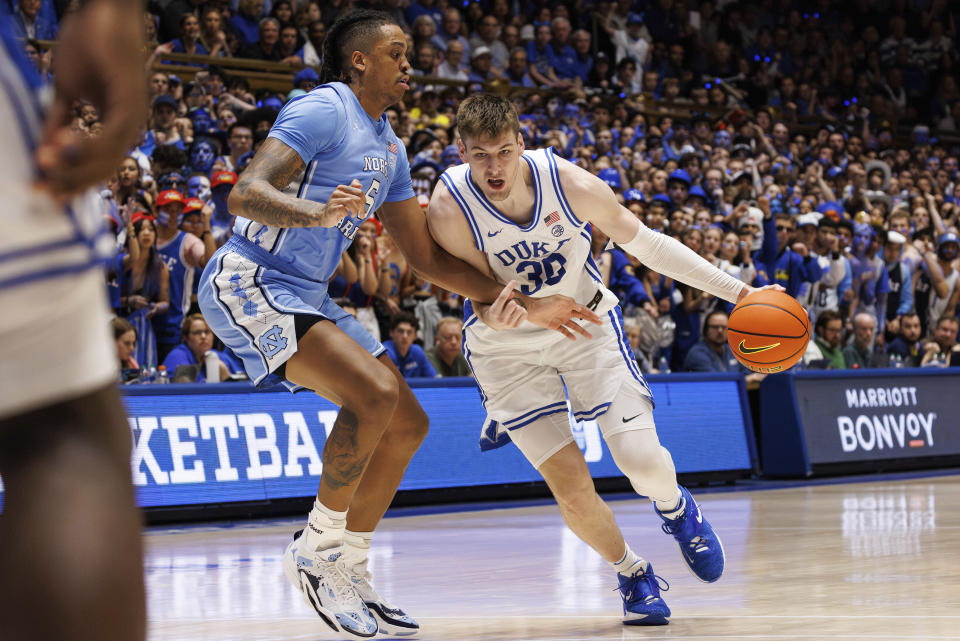 Duke's Kyle Filipowski (30) handles the ball as North Carolina's Armando Bacot (5) defends during the second half of an NCAA college basketball game in Durham, N.C., Saturday, March. 9, 2024. (AP Photo/Ben McKeown)