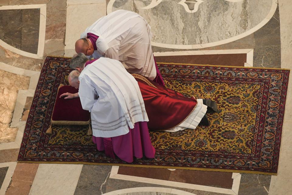 Pope Francis gets assistance as he lies down in prayer prior to celebrate Mass for the Passion of Christ, in St. Peter's Basilica at the Vatican, Friday, April 19, 2019. Pope Francis began the Good Friday service at the Vatican with the Passion of Christ Mass and hours later will go to the ancient Colosseum in Rome for the traditional Way of the Cross procession. (Tiziana Fabi/Pool Photo via AP)